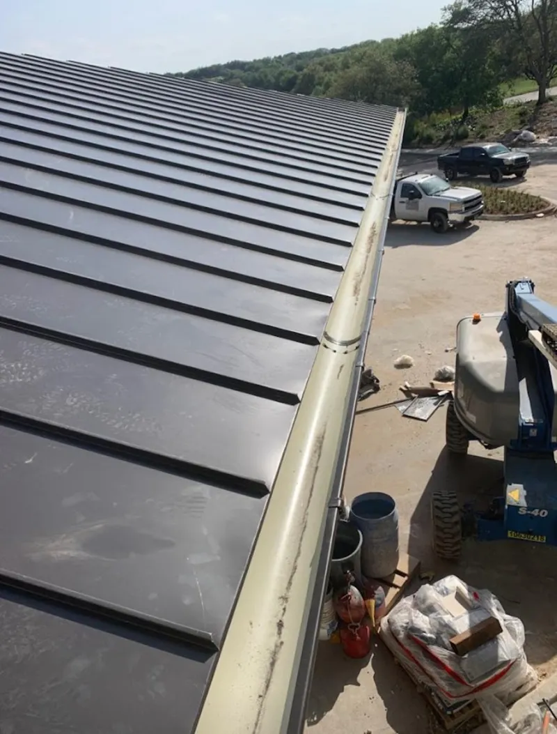 Standing seam panel and gutter detail on a metal roofing jobsite in Smyrna